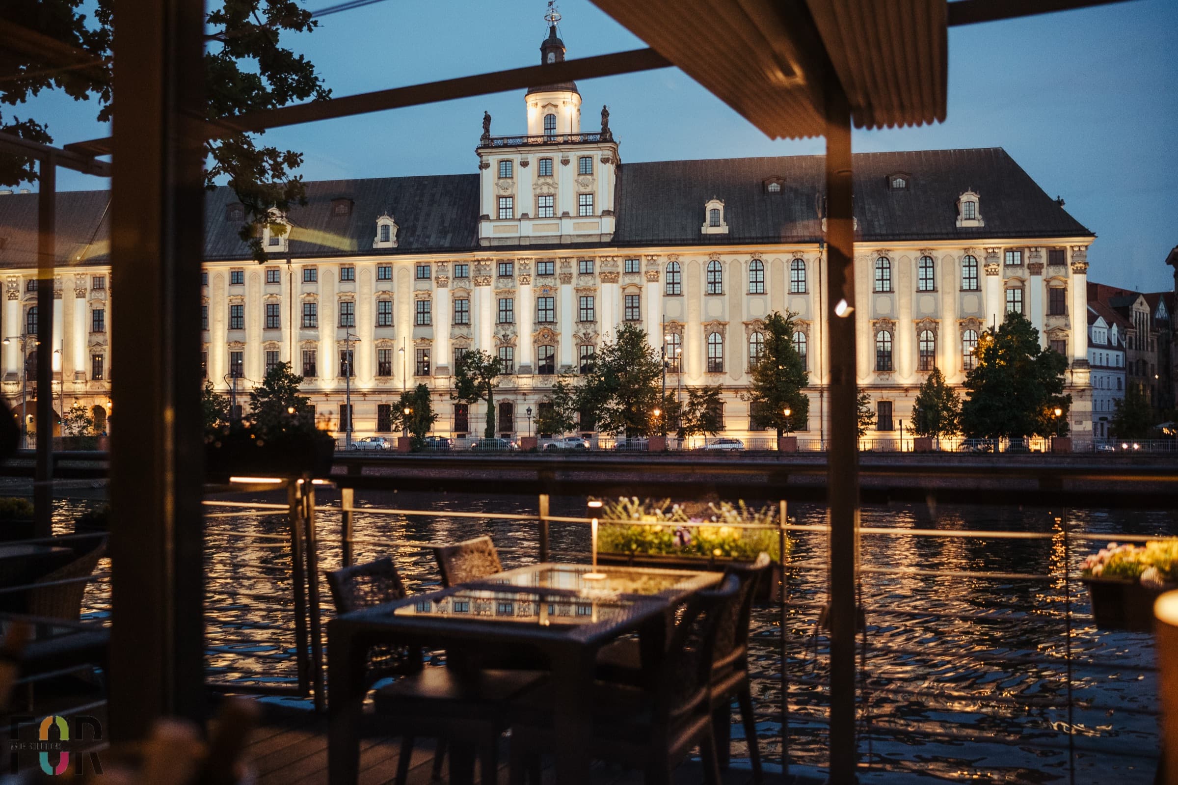 Przystań & Marina — waterfront terrace at dusk overlooking the Oder river and Wrocław University, Wrocław